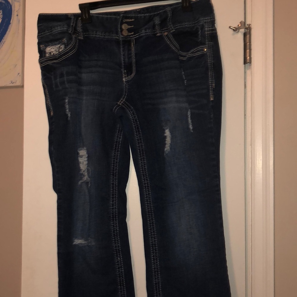 Bootcut distressed jeans. Back pocket detailing
